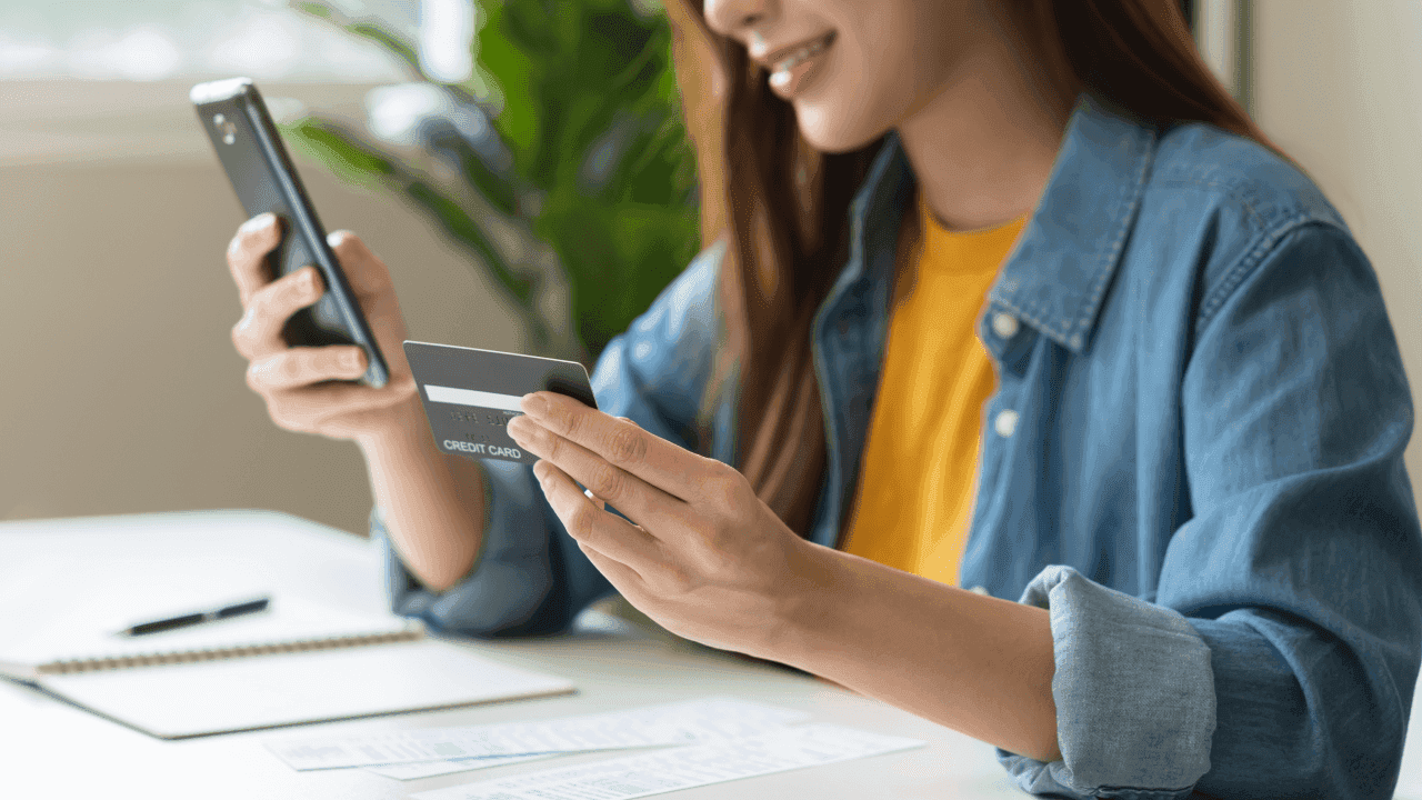 ragazza con carta di credito e cellulare in mano